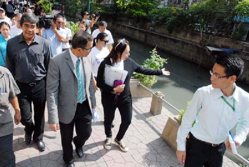 A Saphan Lek vendor, at center, gestures toward Khlong Ong Ang with Deputy Secretary General of the national Ombudsman’s office Thavin Injamnong, second from left, who visited Saphan Lek and the nearby area today for an inspection after vendors filed a complaint Friday with his office.