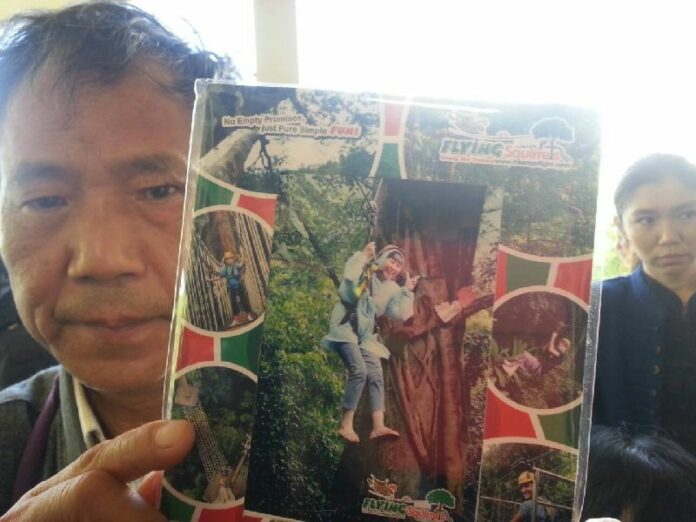 A relative of Wang Qi holds a photograph Thursday showing her enjoying the Flying Squirrels zipline attraction in Chiang Mai province just before her death this past Sunday. Officials there have since acknowledged the popular attractions are unregulated.