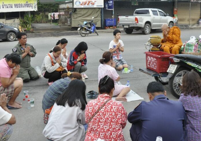 A monk receives alms this morning in Korat on the last day of Buddhist Lent.