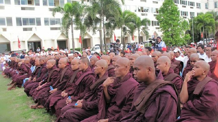 Monks listen to speakers at a National Development Party event in the Mon State capital of Mawlamyine on Oct. 12. The town's Maha Myaing Monastery and Myazedi (Yekyaung) Monastery are said to be the cradle of the radical Buddhist group Ma Ba Tha. Photo: Myanmar Now / Phyo Thiha Cho<br />