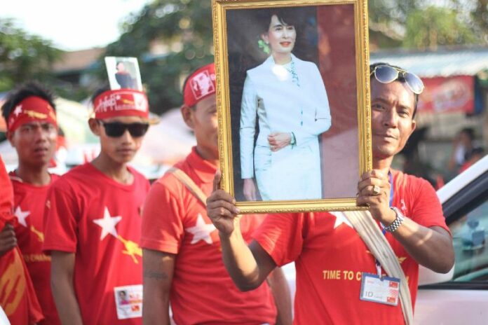 A supporter of Suu Kyi holds a picture of her at a Nov. 1 NLD rally in Thuwunna, Yangon. Photo: Myanmar Now / Thin Lei Win