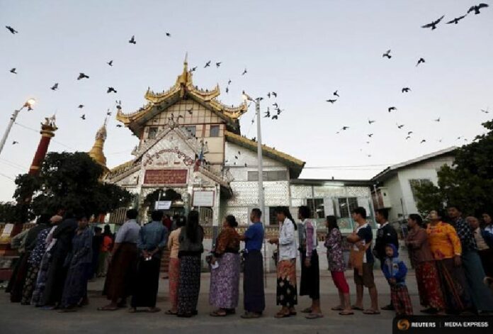 People line up outside a Buddhist prayer hall to vote Sunday during the general election in Mandalay, Myanmar. The vote is Myanmar's first free nationwide election in 25 years, the Southeast Asian nation's biggest stride yet in a journey to democracy. Photo: Reuters / Olivia Harris