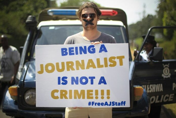 A correspondent working in Nairobi poses with a placard to protest at the imprisonment of three journalists from Al Jazeera's English-language channel in 2015 in Egypt. Photo: EPA / Dai Kurokawa