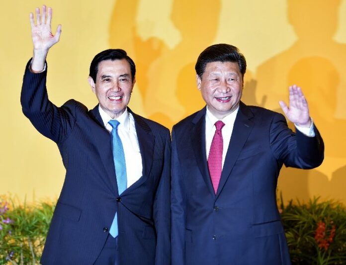 Chinese President Xi Jinping (R) and Taiwan President Ma Ying-jeou wave to journalists before their meeting at Shangrila hotel in Singapore on November 7, 2015. The leaders of China and Taiwan hold a historic summit that will put a once unthinkable presidential seal on warming ties between the former Cold War rivals. AFP PHOTO / Roslan RAHMAN