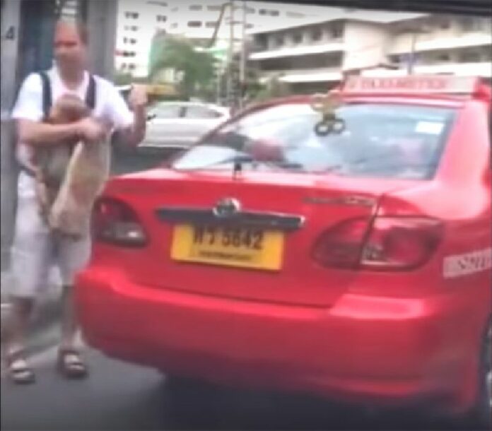 An unidentified foreign man storms out of a taxi with an unidentified baby in Bangkok in a still image from a video posted online Wednesday.