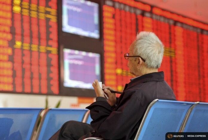 An investor takes notes at a brokerage house Oct. 8 in Fuyang, Anhui province, China. Photo: Reuters