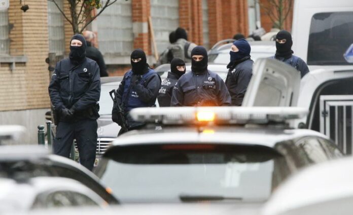 Riot police stand guard at in the streets of Molenbeek, Brussels, where Belgian police carried out an operation aimed at arresting a suspect in the Paris terrorist attacks. Photo: EPA / Olivier Hoslet