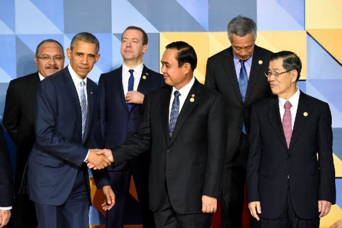 US President Barack Obama shakes hand with junta chairman Prayuth Chan-ocha during group photo at APEC summit today.
