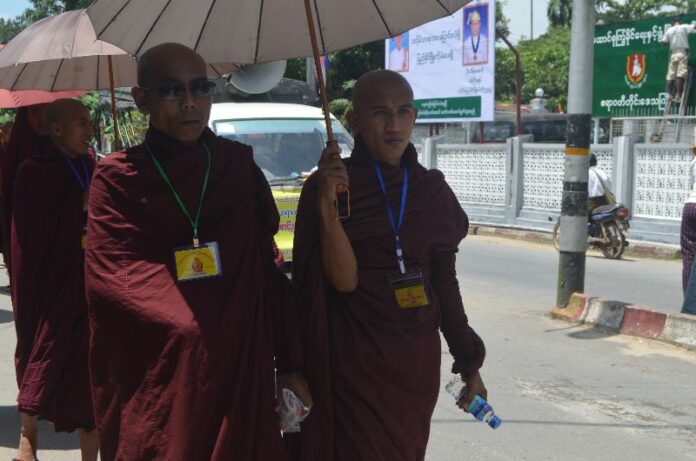 Buddhist monks walk past the office of the Union Solidarity and Development Party in the town of Pathein in the Ayeyarwady Delta this past September to join a rally held to celebrate the success of ‘race and religion’ laws. Photo: Swe Win / Myanmar Now