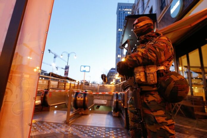 Police officers and soldiers guard a metro station in Brussels. Photo: EPA / Laurent Dubrule