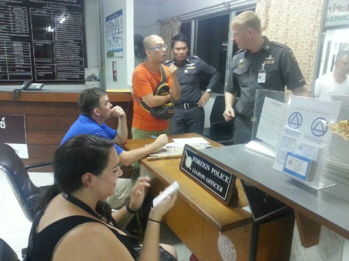 Tourists at the Chiang Mai city police station last night speak to a foreign police liaison.