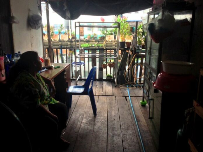 A family member of Sujit Artpru, head of the Khlong Bang Bua community, sits Nov. 20 in the temporary shelter they moved into while their home is demolished to make way for redevelopment of the canal.