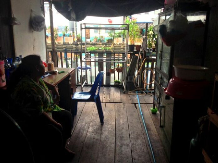 A family member of Sujit Artpru, head of the Khlong Bang Bua community, sits Nov. 20 in the temporary shelter they moved into while their home is demolished to make way for redevelopment of the canal.