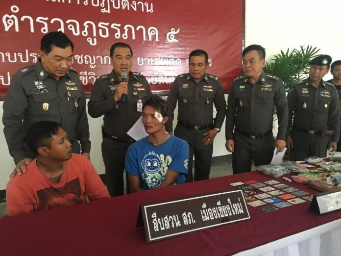 Suradetch Mokpha sits at left with one of his alleged accomplices at a police news conference today in Chiang Mai.
