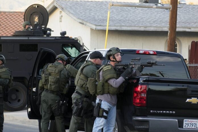 Police in San Bernardino, California, scour a residential neighborhood for a possible third suspect after trading gunfire with occupants of a vehicle linked to an earlier massacre that killed at least 14 people. Photo: Eugene Garcia / EPA