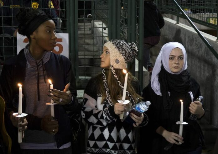 Mourners hold candles at a candlelight vigil Thursday for the victims of the gun attack in San Bernardino, California. Photo: Eugene Garcia / EPA<br />