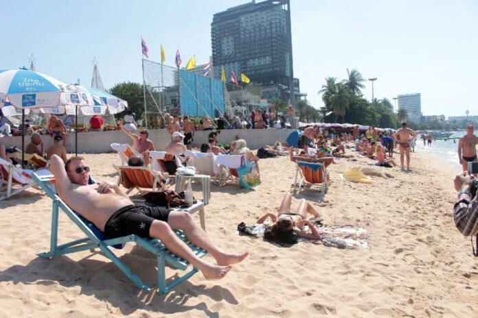Foreign tourists relax on Pattaya Beach in a December 2014 file photo.
