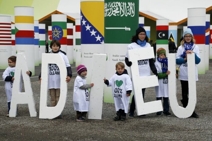 Children display giant letters spelling out the French word 'Adieu' (Goodbye), part of a larger display bidding farewell to the use of fossil fuels earlier this month outside the U.N. climate talks in Paris. Photo: Jose Rodriguez / EPA<br />