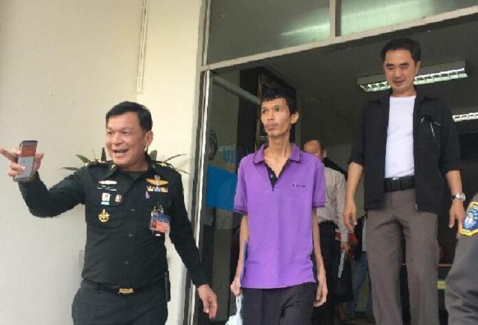 Security officers today escorted Thanakorn Siripaiboon (in purple) to the martial court for an arraignment on his lese majeste charge.