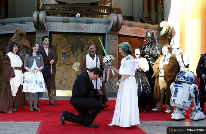 Andrew Porters kneels in front of Caroline Whitter on Thursday in front of the Chinese Theatre in Hollywood, California. Photo: Mario Anzuoni / Reuters<br />