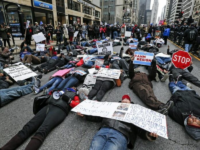 Protesters lie in the street during a demonstration along Michigan Avenue's Magnificent Mile shopping area, Chicago, Illinois, Dec. 24. Photo: Tannen Maury / EPA