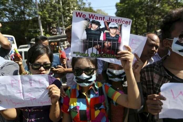 Protesters hold pictures of Zaw Lin and Win Zaw Htun, in front of the Thai embassy in Yangon Dec. 25. Photo: Soe Zeya Tun / Reuters