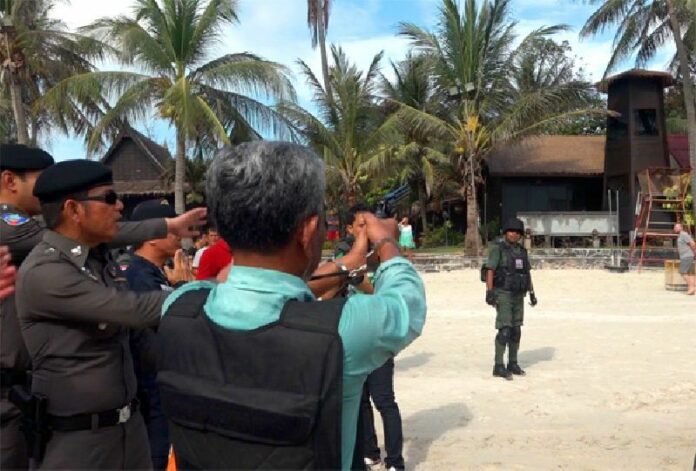 Suspected gunman Sihanath Chaipinit participates in a police 're-enactment' Saturday in front of the Palita Lodge on Koh Phangan.