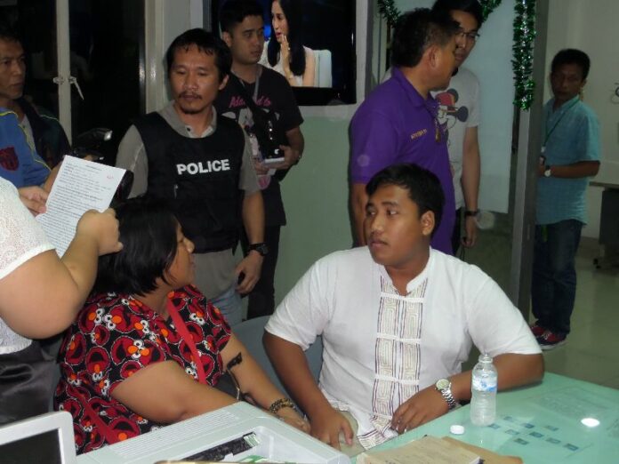 Sirawith Serithiwat seated next to his mother at Nimitmai Police Station, early Thursday morning after soldiers transferred him to police custody.