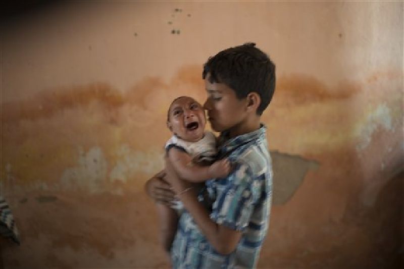 10-year-old Elison nurses his 2-month-old brother Jose Wesley, who was born with microcephaly, at their house Dec. 23 in Poco Fundo, Brazil. Photo: Felipe Dana / AP