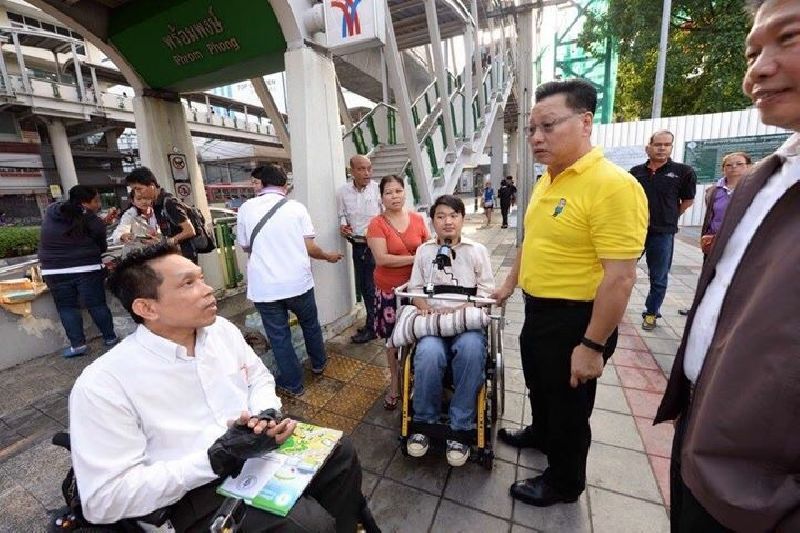 Disabled rights activist Manit Inpim, who spearheaded efforts to make the rail system accessible with Transportation for All, talks to Deputy Bangkok Gov. Amorn Kijchawengkul on Jan. 21 at BTS Phrom Phong in Bangkok.