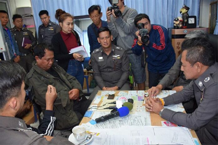 Sen. Sgt. Maj. Theerayut Phetjit, seated second from left, is shown to reporters Tuesday in a Chonburi province police station.