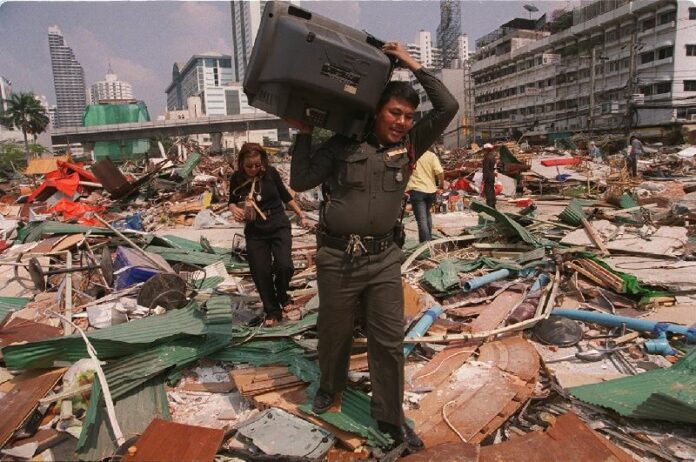 A police officer removes an intact television from a sea of debris in a Jan. 27 file photo of land demolished in Soi Sukhumvit 10.