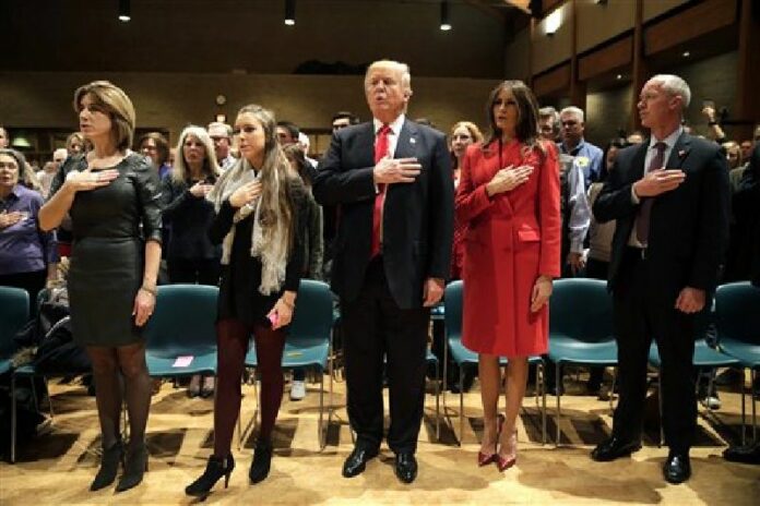 Republican presidential candidate Donald Trump, at center, and wife Melania recite the Pledge of Allegiance on Monday in West Des Moines, Iowa. Photo: Jae C. Hong / Associated Press