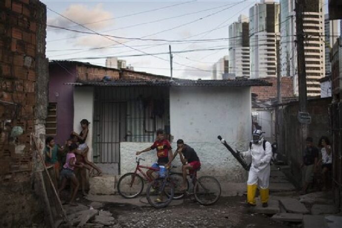 Young residents run away and others cover their faces as a municipal worker sprays insecticide to combat mosquitoes that transmit the Zika virus Jan. 26b in Brazil. Photo: Felipe Dana / Associated Press<br />