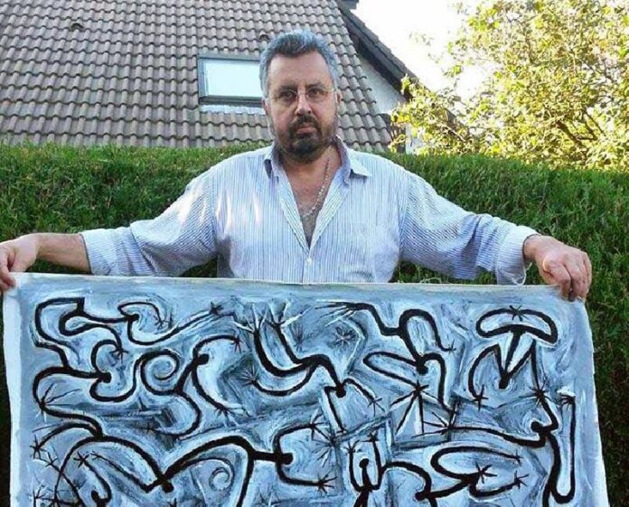 The Nation political cartoonist Stephane 'Stephff' Peray poses with one of his paintings in a photo posted online Sept. 20. Photo: Stephane Peray / Facebook