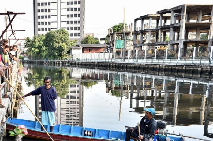 Waste collector Phlun Juithongkam, at right, on Khlong Lat Phrao where he found a body Wednesday morning.
