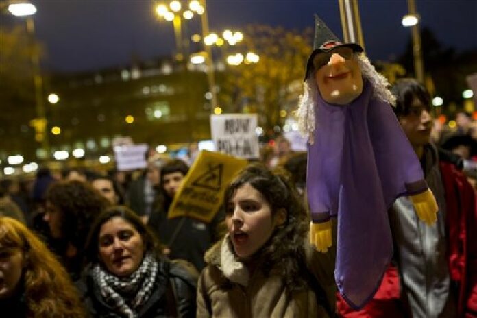 People, one of them holding a puppet, gather outside Madrid city hall in support of two puppeteers who were detained without bail last Friday for using a sign saying, "Long Live Alka ETA," in a word-play reference to Spain's armed Basque group ETA and al-Qaida, in Madrid, Wednesday, Feb. 10, 2016. Photo: Francisco Seco / Associated Press
