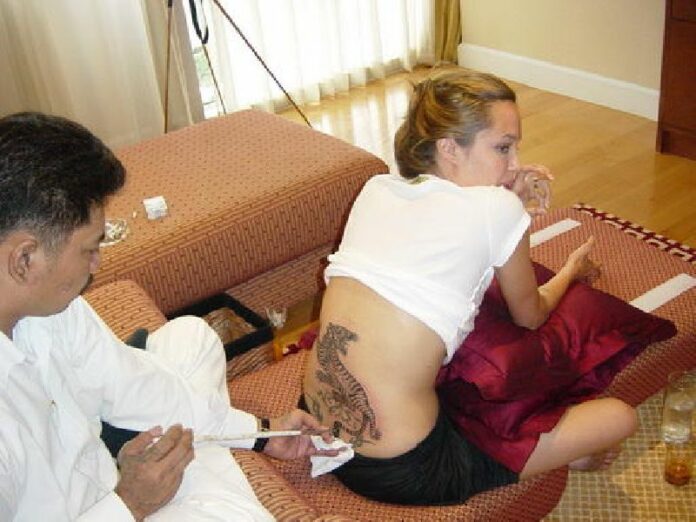 Ajarn Noo tattoos a tiger on Angelina Jolie’s lower back in July, 2004. Photo: www.ajarnnookanpai.com