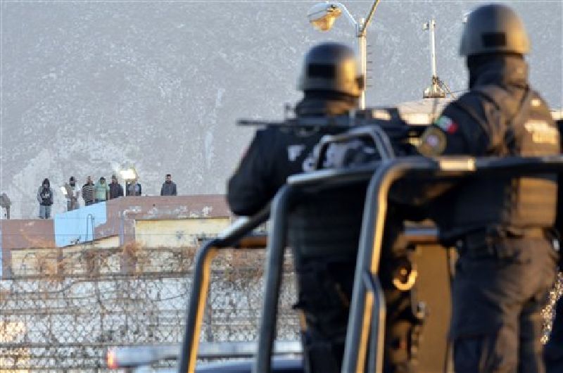 Inmates stand on the rooftop of the Topo Chico prison as police stand guard on the perimeters, after a riot broke out around midnight, in Monterrey, Mexico, Thursday, Feb. 11, 2016. Photo: Emilio Vazquez / Associated Press