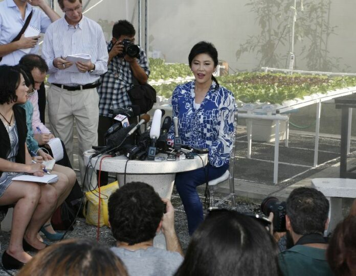 Former Prime Minister Yingluck Shinawatra speaks to reporters Friday in her home organic garden in Bangkok.