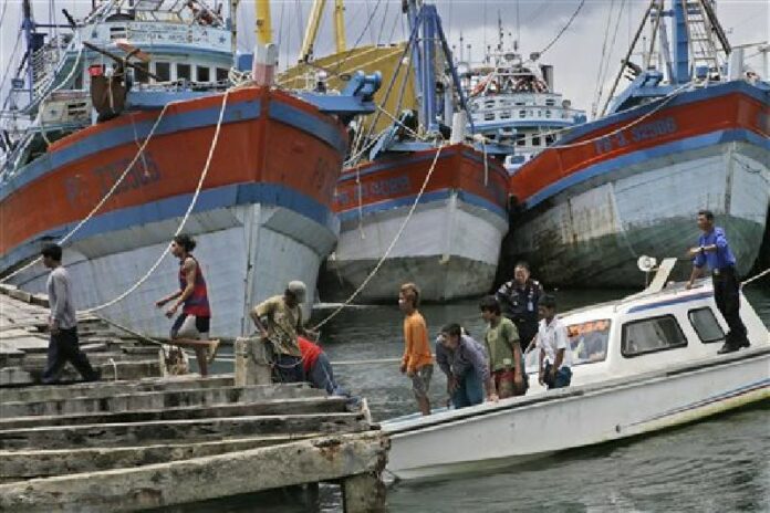 Burmese fishermen arrive at the compound of Pusaka Benjina Resources to report themselves for departure to leave the fishing company in Benjina, Aru Islands, Indonesia as hundreds of foreign fishermen rush at the chance to be rescued from the isolated island where an Associated Press report revealed slavery runs rampant in the industry in an April 3, 2015 file photo. Photo: Dita Alangkara / Associated Press<br />