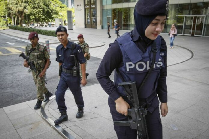 Malaysian military and police personnel patrol Jan. 25 outside a shopping mall in Kuala Lumpur, Malaysia. Photo: Joshua Paul / Associated Press<br />