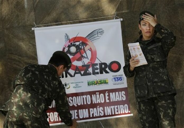 In this Saturday, Feb. 13, 2016 file photo, army soldiers set up a sign that reads in Portuguese "A mosquito is not stronger than an entire country" at the Central station in Rio de Janeiro, Brazil. Photo: Silvia Izquierdo / Associated Press.