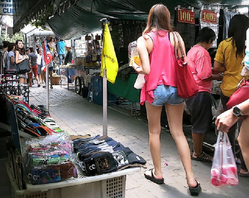 A pedestrian walks through stalls specializing in apparel and fashion items in Bangkok’s Pratunam area. Photo: Jef1947 / Flickr