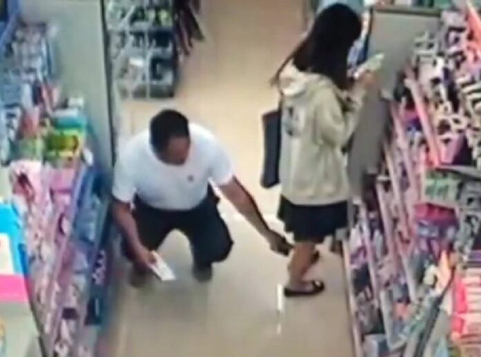 A scene from security camera footage from Tuesday shows police Sub. Lt. Nopparat Chaiwong placing his mobile phone to film up a female student’s skirt.