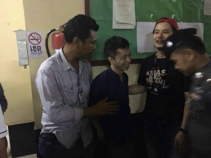 Yang Zheng, at center, in custody Saturday at the Nakhon Sawan Train Station.