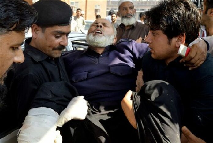 Volunteers carry an injured man to a hospital in Peshawar, Pakistan, Monday, Mar. 7, 2016. Photo: Mohammad Sajjad / Associated Press