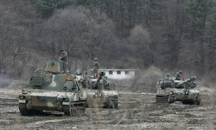 South Korean army soldiers stand on K-55 self-propelled howitzers during an annual exercise Monday in Paju, near the border with North Korea. Photo: Ahn Young-joon / Associated Press<br />