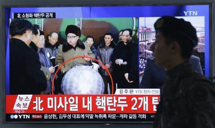 A South Korean army soldier walks by a TV screen showing North Korean leader Kim Jong Un with superimposed letters that read: "North Korea's nuclear warhead" during a news program at Seoul Railway Station in Seoul, South Korea, Wednesday, March 9, 2016. Photo: Ahn Young-joon / Associated Press