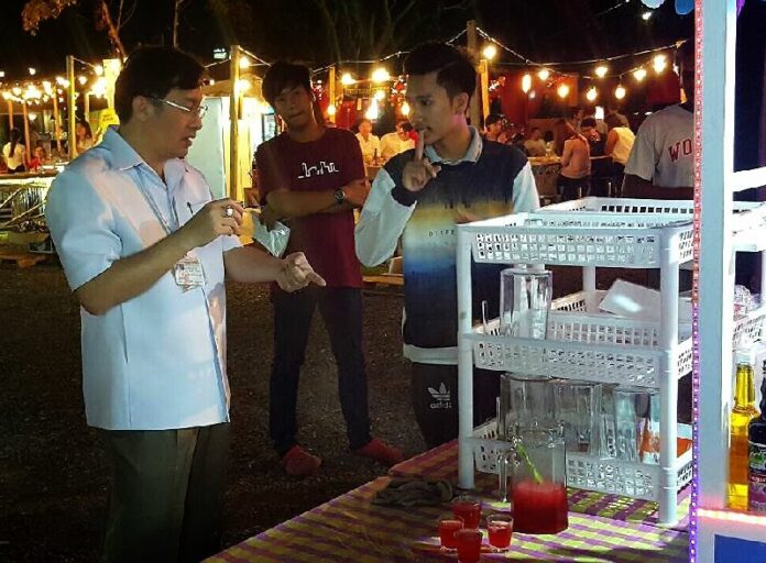 Samarn Futrakul lectures a vendor Friday night as he busts a 'lao pan' stand Friday night near Lumpini Park in Bangkok.